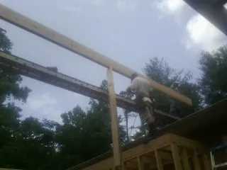 Carpenter setting a ridge beam over a new addition frame — Ice Dam Removal by Roofing Brothers in Newport Beach