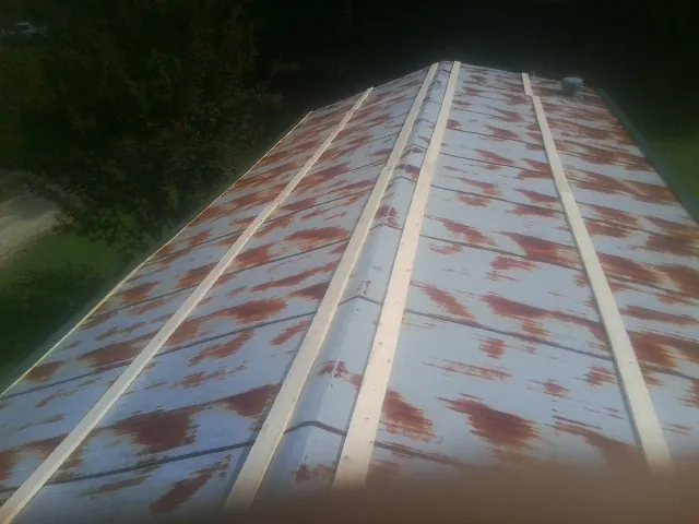 Rusted metal roof panels with new wood purlins before replacement — Storm Damage Roof Repair in Newport Beach by Roofing Brothers